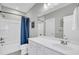 Well-lit bathroom showcasing a vanity, shower-tub combo with a blue curtain, and white tile at 4603 Scout Aly, North Charleston, SC 29405
