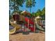 A colorful playground with slides and climbing structures surrounded by trees at 4800 Wheatfield Dr, Summerville, SC 29485