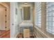 Charming bathroom with a pedestal sink, shuttered window, and classic fixtures providing a bright and clean aesthetic at 4874 Sound View Dr, Mount Pleasant, SC 29466