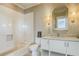 Bathroom features tiled tub, stylish vanity with marble top, and decorative sconces at 4874 Sound View Dr, Mount Pleasant, SC 29466