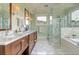 This bathroom boasts dual sinks with marble counters, a glass shower, and luxurious soaking tub at 4874 Sound View Dr, Mount Pleasant, SC 29466