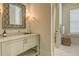 Elegant bathroom featuring a marble countertop, a decorative mirror, and a glimpse into the adjacent toilet room at 4874 Sound View Dr, Mount Pleasant, SC 29466