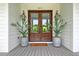 Elegant double front doors with glass inserts flanked by planters and lanterns at 4874 Sound View Dr, Mount Pleasant, SC 29466