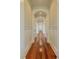 Long hallway featuring hardwood flooring, white trim, and arched entryways at 4874 Sound View Dr, Mount Pleasant, SC 29466