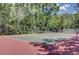 Outdoor tennis court with green surface and red border surrounded by trees, ideal for recreation at 4874 Sound View Dr, Mount Pleasant, SC 29466