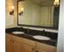 Bathroom featuring double sinks with granite countertop, wooden cabinetry, and modern lighting at 5009 Old Bridgeview Ln # 5009, Charleston, SC 29403