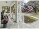 Inviting front porch with rocking chairs, complemented by lush greenery and a charming American flag at 5108 Celtic Dr, North Charleston, SC 29405