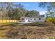 Backyard featuring a wooden fence, white exterior, and mature trees at 671 Riley Rd, Charleston, SC 29412