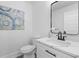 Modern powder room with white vanity, black accents and unique artwork at 671 Riley Rd, Charleston, SC 29412