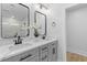 Modern bathroom with double sinks, decorative mirrors, black fixtures, and grey cabinets at 671 Riley Rd, Charleston, SC 29412