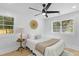 Bright bedroom with light wood floors and a cozy queen bed under a ceiling fan, lit by two windows at 671 Riley Rd, Charleston, SC 29412