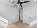 An airy bedroom with wood floors, black ceiling fan, and white trim, showcasing a door to an adjacent room at 671 Riley Rd, Charleston, SC 29412
