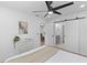 Bright bedroom features wood paneled walls, ceiling fan, and sliding barn doors to the ensuite bathroom at 671 Riley Rd, Charleston, SC 29412