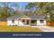 Charming, renovated single-story home featuring a white brick facade, a wood-accented porch, and a well-maintained front yard at 671 Riley Rd, Charleston, SC 29412