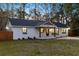Beautifully renovated home with white brick, a dark roof, and welcoming front porch at dusk at 671 Riley Rd, Charleston, SC 29412