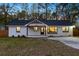Inviting home showcasing a white brick exterior, black roof, and well-lit windows at 671 Riley Rd, Charleston, SC 29412