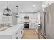 Open kitchen featuring white cabinets, stainless steel appliances, and a large waterfall island with bar stool seating at 671 Riley Rd, Charleston, SC 29412