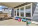 View of back porch featuring concrete flooring, swing, and three large windows at 69 Arrowwood Way, Summerville, SC 29485