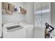Well-lit laundry room with washer, dryer, overhead shelving, and a large window for natural light at 69 Arrowwood Way, Summerville, SC 29485