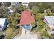 Beautiful aerial view of a beach home with a red roof, surrounded by mature trees, and set back from the road at 716 E Arctic Ave, Folly Beach, SC 29439