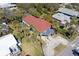 Aerial shot of a charming beach house with a red roof, spacious driveway, lovely blue porch, and surrounding palm trees at 716 E Arctic Ave, Folly Beach, SC 29439