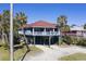 Inviting beach house with beautiful tropical landscaping, and a spacious drive way at 716 E Arctic Ave, Folly Beach, SC 29439