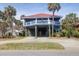 Inviting beach house with beautiful tropical landscaping and a spacious drive way at 716 E Arctic Ave, Folly Beach, SC 29439