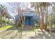 Charming blue home with palm trees in the background, sitting on stilts at 716 E Arctic Ave, Folly Beach, SC 29439