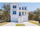 Beautiful three-story coastal home with a double garage, covered porch, and manicured lawn at 716 Minton Rd, Charleston, SC 29412