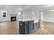 Modern kitchen island featuring a farmhouse sink and stainless-steel appliances open to a living room with a fireplace at 718 Minton Rd, Charleston, SC 29412