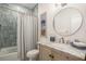 Charming bathroom with a vintage-style vanity, round mirror, and tiled shower at 750 Atlantic St, Mount Pleasant, SC 29464