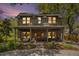 Charming two-story home featuring a welcoming front porch and meticulously landscaped front yard at dusk at 750 Atlantic St, Mount Pleasant, SC 29464