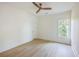 Clean bedroom with hardwood floors, a wood ceiling fan, a single window, and a white door at 755 Adluh St, Mount Pleasant, SC 29464