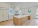 Bright kitchen featuring a large island with white countertop, white cabinets, gold fixtures, and stainless appliances at 755 Adluh St, Mount Pleasant, SC 29464