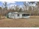 Exterior view of a white house with green trim and a screened in porch in a grassy lot with trees at 7560 Cottageville Hwy, Round O, SC 29474