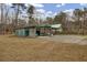Open-air garage with a metal roof, concrete floor, and storage space in a grassy lot with trees at 7560 Cottageville Hwy, Round O, SC 29474
