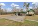 Open-air garage with a metal roof, concrete floor, and storage space in a grassy lot with trees at 7560 Cottageville Hwy, Round O, SC 29474