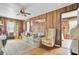 Cozy living room with wood paneling, ceiling fan, and doorway views at 7560 Cottageville Hwy, Round O, SC 29474