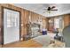 Wood-paneled living room with a brick fireplace, wood floors, and ample seating at 7560 Cottageville Hwy, Round O, SC 29474