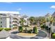 View of the complex, with palm trees lining the circular driveway, showing the building's layout and landscaping at 9000 Palmetto Dr # G203, Isle of Palms, SC 29451