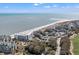 Expansive aerial showcasing beachfront condos, the ocean and a golf course, creating a serene coastal landscape at 9000 Palmetto Dr # G203, Isle of Palms, SC 29451