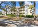View of the building exterior showing multiple balconies, lush greenery, and proximity to natural surroundings at 9000 Palmetto Dr # G203, Isle of Palms, SC 29451