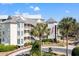 Charming multi-story building with private balconies, lush landscaping, and an American flag in a circular drive at 9000 Palmetto Dr # G203, Isle of Palms, SC 29451