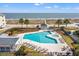 Aerial view of community pool and hot tub surrounded by lounge chairs and greenery, steps from the beach at 9000 Palmetto Dr # G203, Isle of Palms, SC 29451