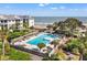 Inviting community pool with lounge chairs, lush landscaping, and ocean views perfect for relaxation and enjoyment at 9000 Palmetto Dr # G203, Isle of Palms, SC 29451