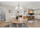 Open dining area boasts wood table, white chairs, chandelier, and seamless flow into the kitchen and living area at 9116 Fieldstone Trace, Summerville, SC 29485