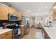 Bright kitchen features stainless steel appliances, wood cabinets, and a view into the dining area at 9116 Fieldstone Trace, Summerville, SC 29485