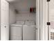 Laundry area with white washer and dryer nestled in a closet space with shelving at 9116 Fieldstone Trace, Summerville, SC 29485