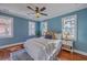 Charming bedroom with blue walls, hardwood floors, ceiling fan, and natural light from multiple windows at 10 Humphrey Ct, Charleston, SC 29403
