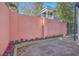 Enclosed courtyard with a tall pink wall, beautiful flowers, and stone pavers, perfect for outdoor enjoyment at 10 Humphrey Ct, Charleston, SC 29403